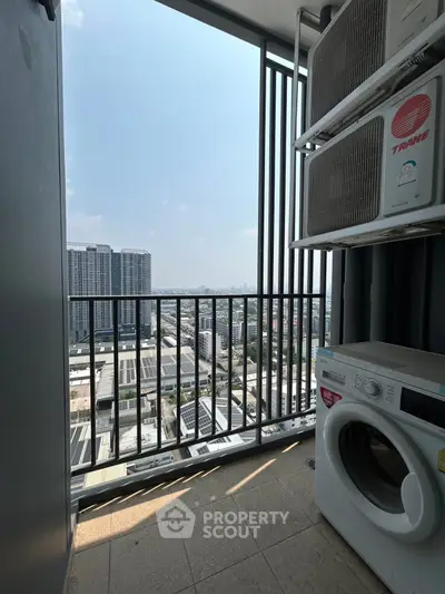 High-rise balcony with city view, featuring washing machine and air conditioning units.