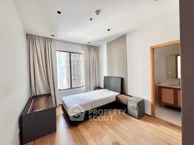 Spacious bedroom with modern furnishings and large window for natural light.