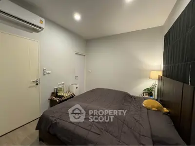 Cozy bedroom with modern decor and soft lighting, featuring a comfortable bed and air conditioning.