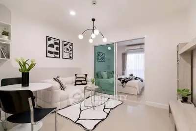 Modern open-plan living room with stylish decor and cozy bedroom view.