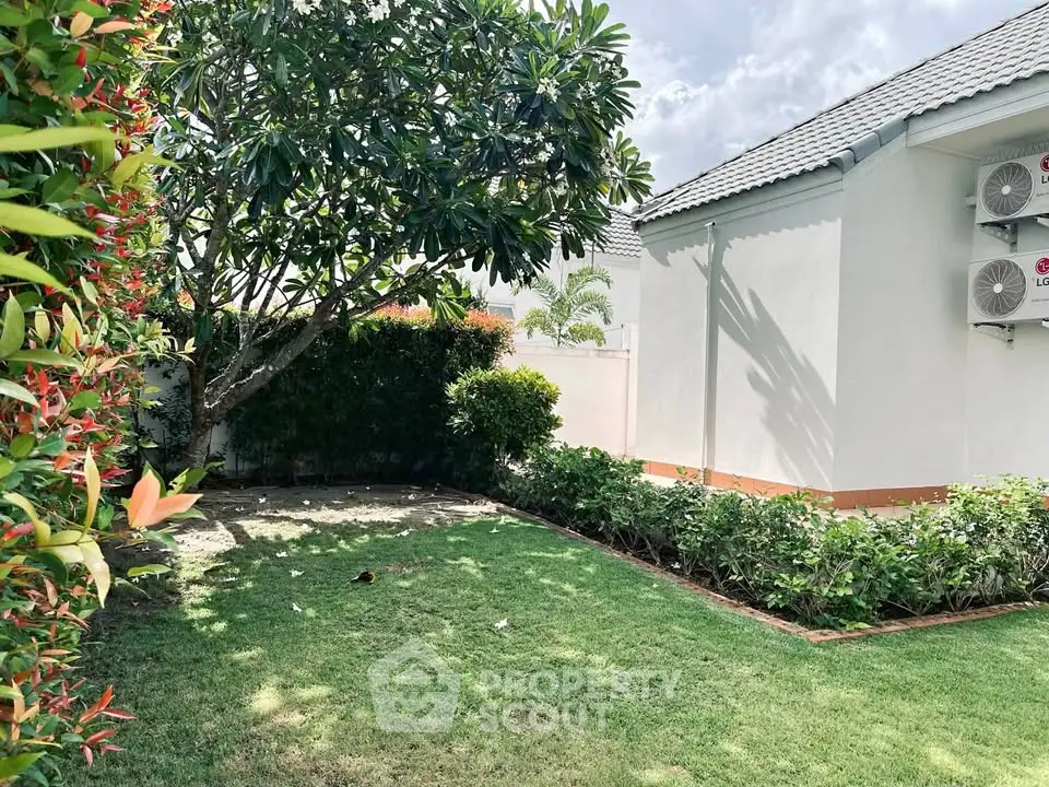 Charming garden view with lush greenery and modern building exterior, perfect for relaxation and outdoor enjoyment.