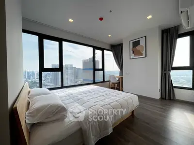 Spacious bedroom with stunning city view and modern decor in high-rise apartment.