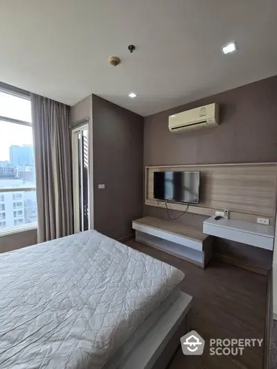 Modern bedroom with city view, featuring air conditioning and wall-mounted TV, perfect for urban living.