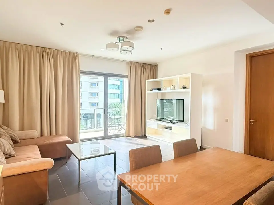 Spacious living room with modern furniture and large windows in a stylish apartment.