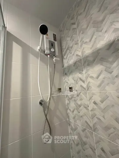 Modern bathroom with stylish herringbone tiles and sleek shower setup