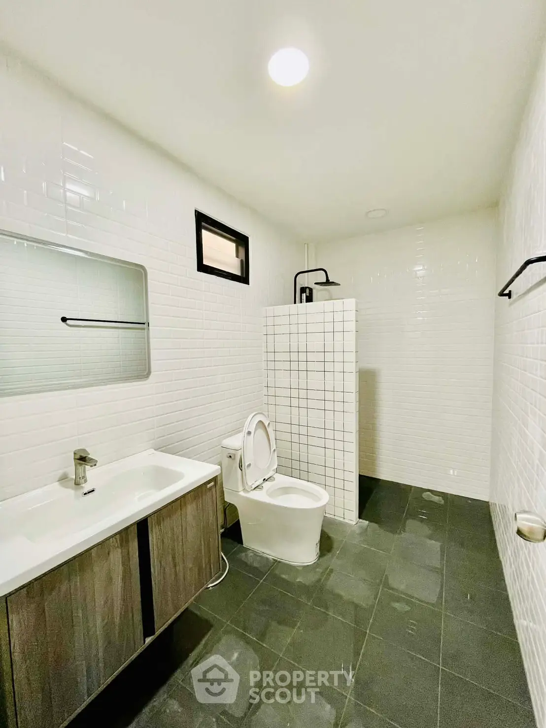 Modern bathroom with sleek design, featuring a white tiled shower and contemporary fixtures.