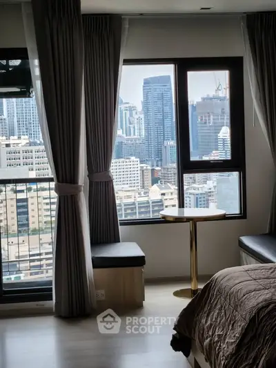Luxurious bedroom with stunning city view from large windows, featuring elegant curtains and modern decor.