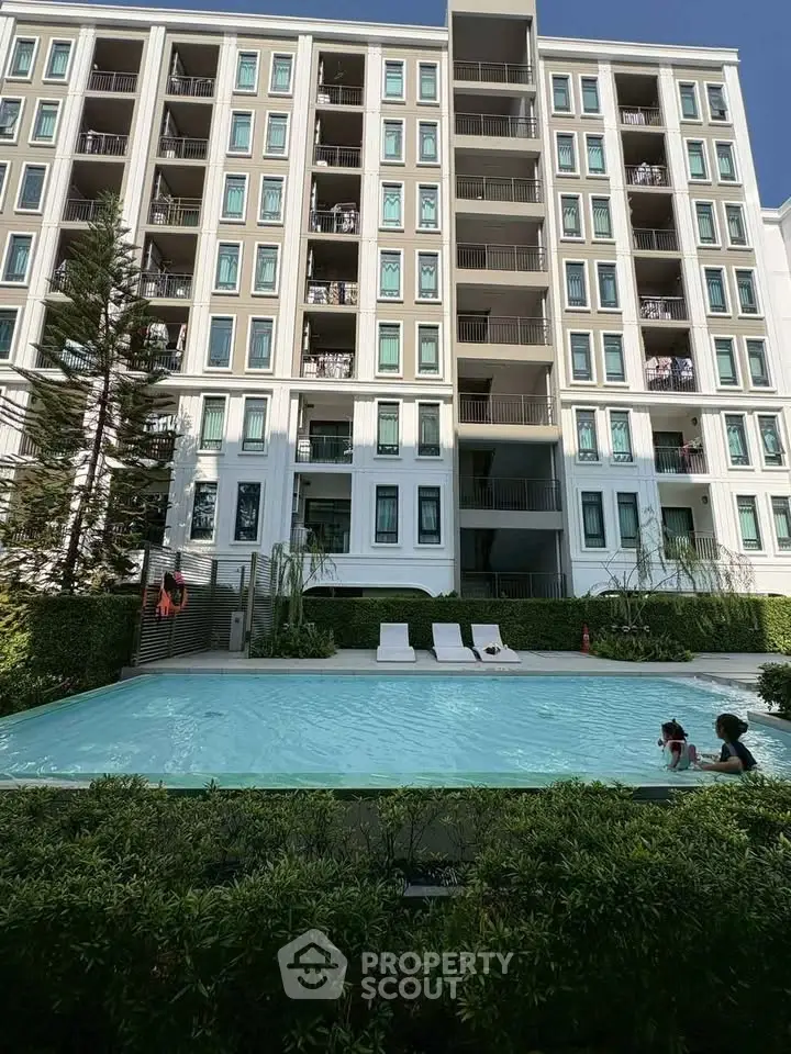 Modern apartment building with pool and lush greenery, perfect for urban living.