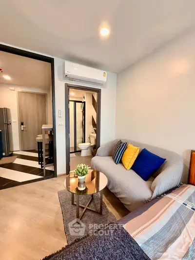 Modern living room with cozy sofa and open view to kitchen and bathroom