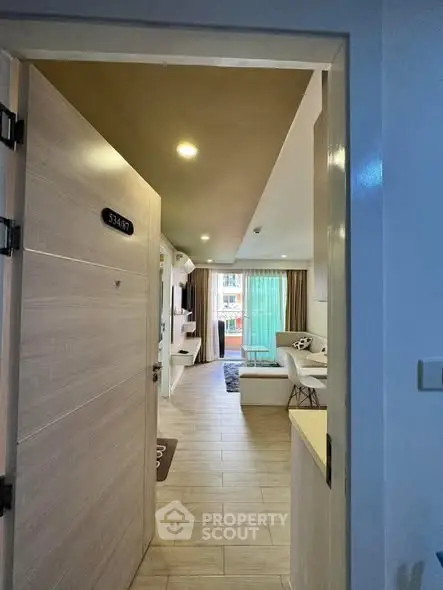 Modern apartment entrance leading to stylish living room with balcony view.