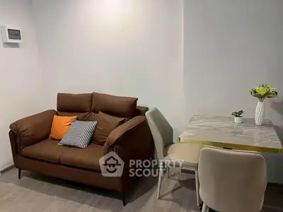 Cozy living room with modern sofa and dining table, perfect for small apartments.