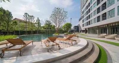Luxurious apartment complex with serene poolside and modern architecture.