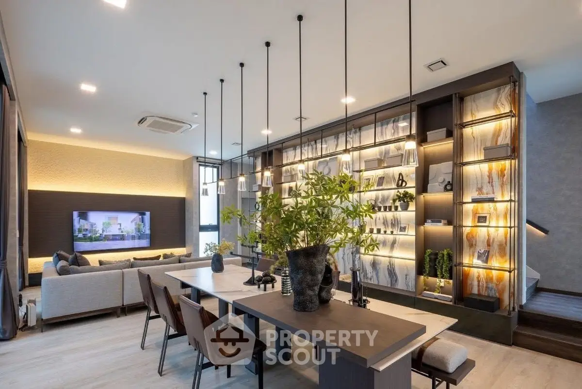 Modern living room with stylish decor and open layout, featuring elegant lighting and a cozy seating area.