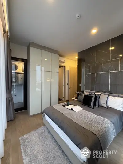 Modern bedroom with stylish decor and built-in wardrobe in a high-rise apartment.