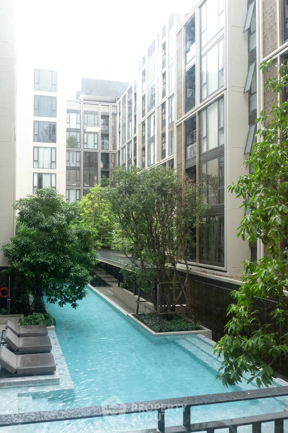 Luxurious residential building with serene pool and lush greenery