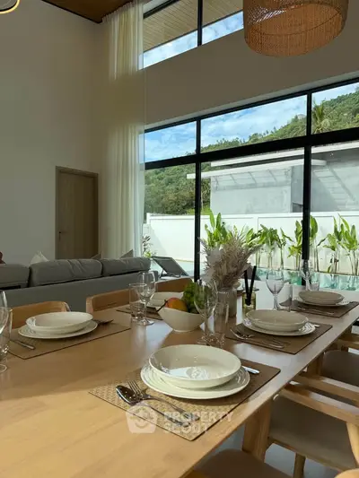 Spacious dining area with elegant table setting and large windows offering scenic views.
