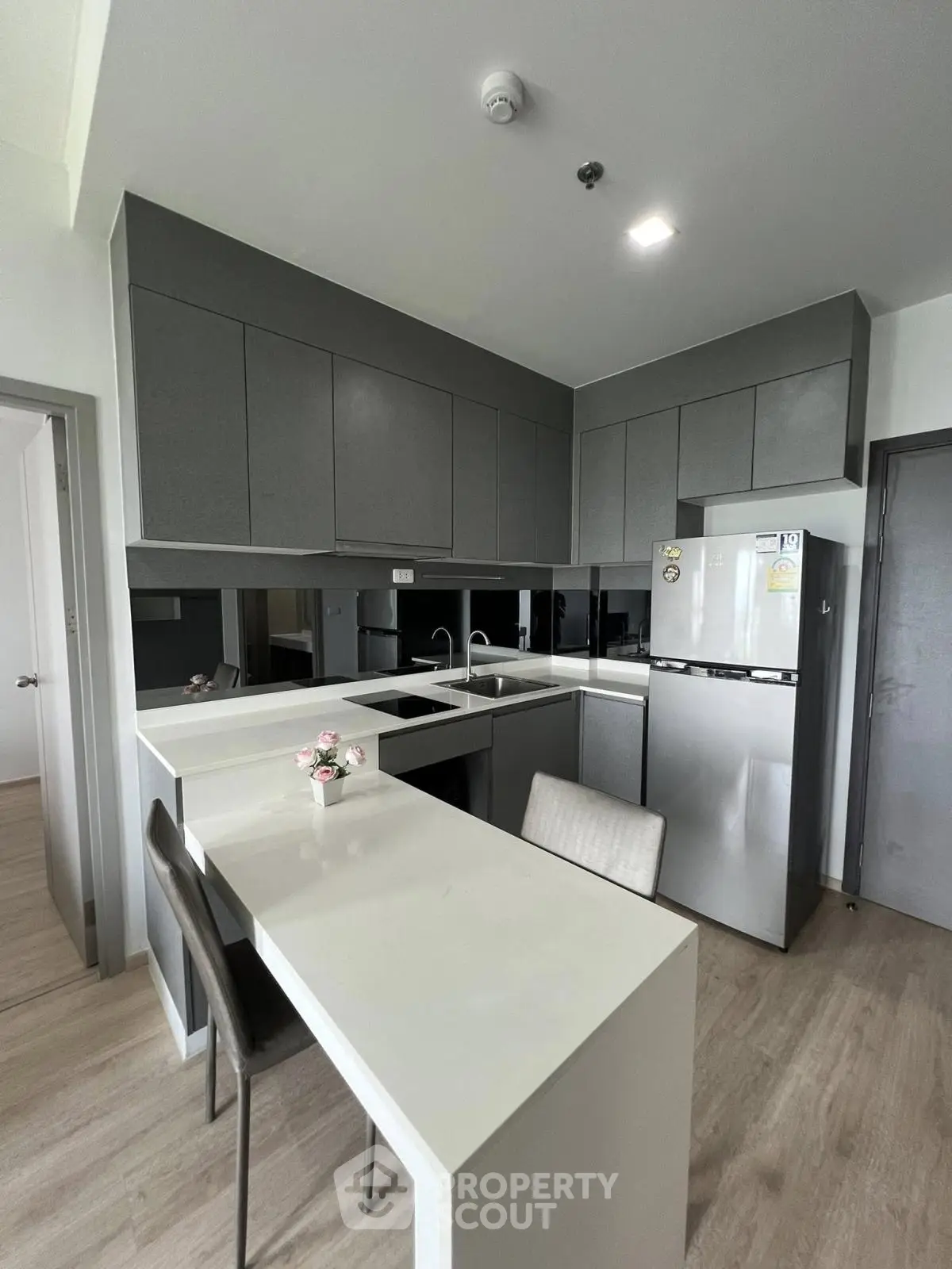 Modern kitchen with sleek cabinetry and stainless steel appliances in a contemporary apartment.