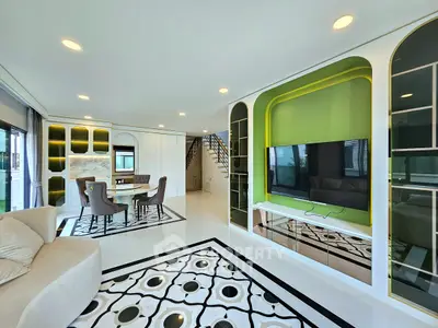 Luxurious modern living room with stylish decor and open layout, featuring elegant furniture and a large TV.