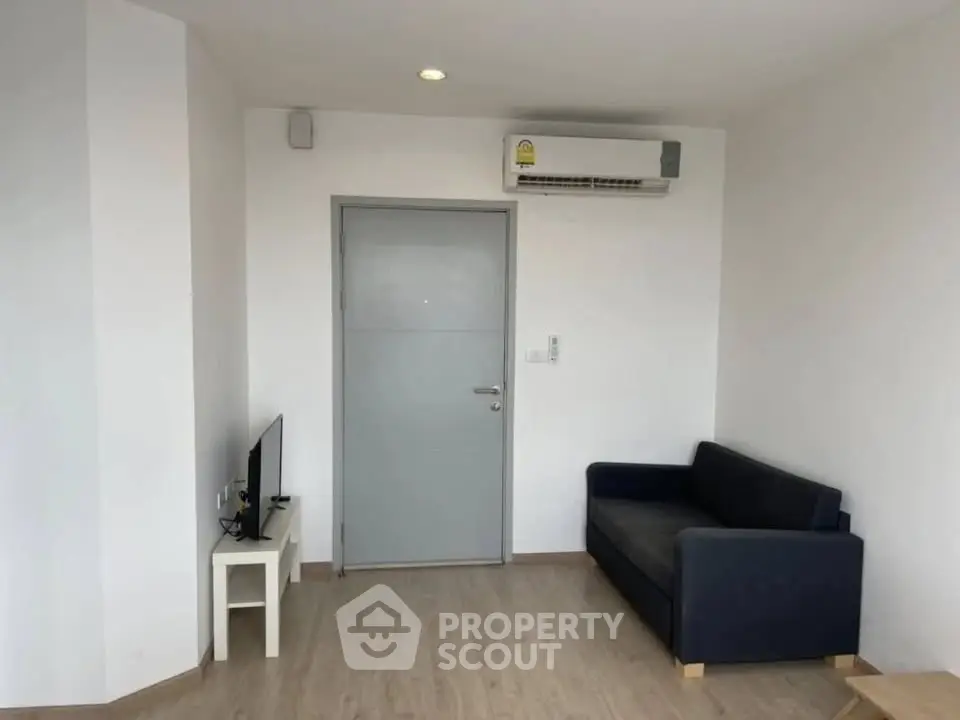 Modern minimalist living room with sleek sofa and wall-mounted air conditioner