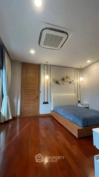 Modern bedroom with wooden flooring and stylish decor
