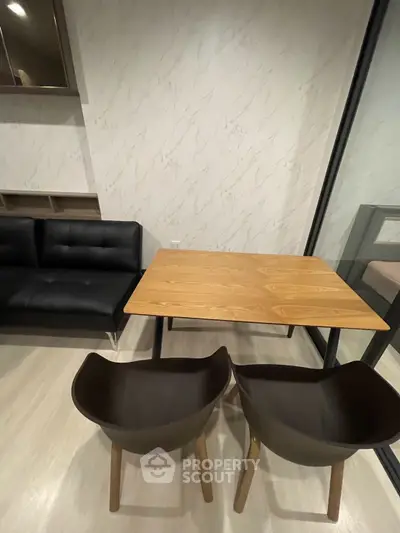 Modern interior with stylish dining area and sleek black sofa, perfect for urban living.