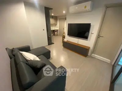 Modern living room with sleek furniture and wall-mounted TV in a stylish apartment.