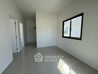 Spacious empty room with large window and glossy tiled floor, perfect for customization.