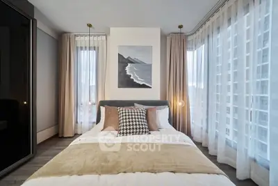 Modern bedroom with floor-to-ceiling windows and stylish decor in a high-rise apartment.