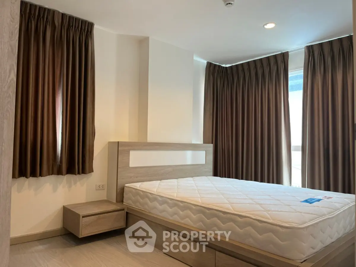 Modern bedroom with large windows and elegant curtains in a stylish apartment.
