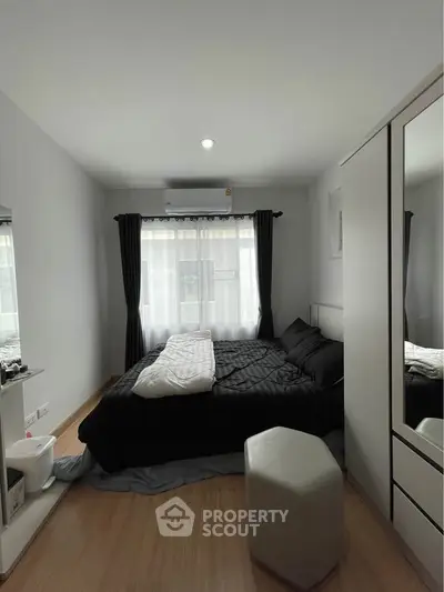 Cozy bedroom with modern decor and natural light, featuring a comfortable bed and stylish furnishings.