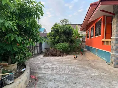 Charming suburban home with vibrant orange exterior and spacious driveway.
