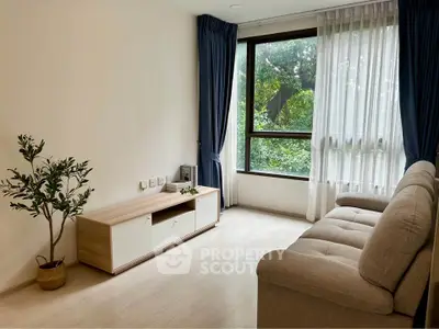 Bright and cozy living room with large window and modern furnishings.