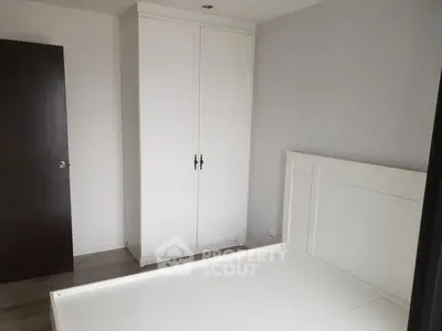 Minimalist bedroom with white wardrobe and bed frame, perfect for modern living.