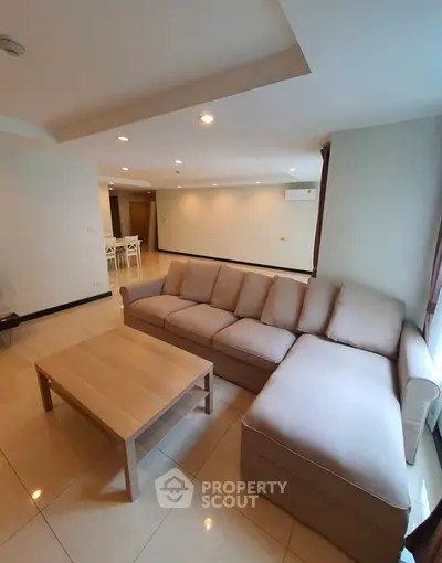 Spacious living room with modern sofa and coffee table in a bright apartment.
