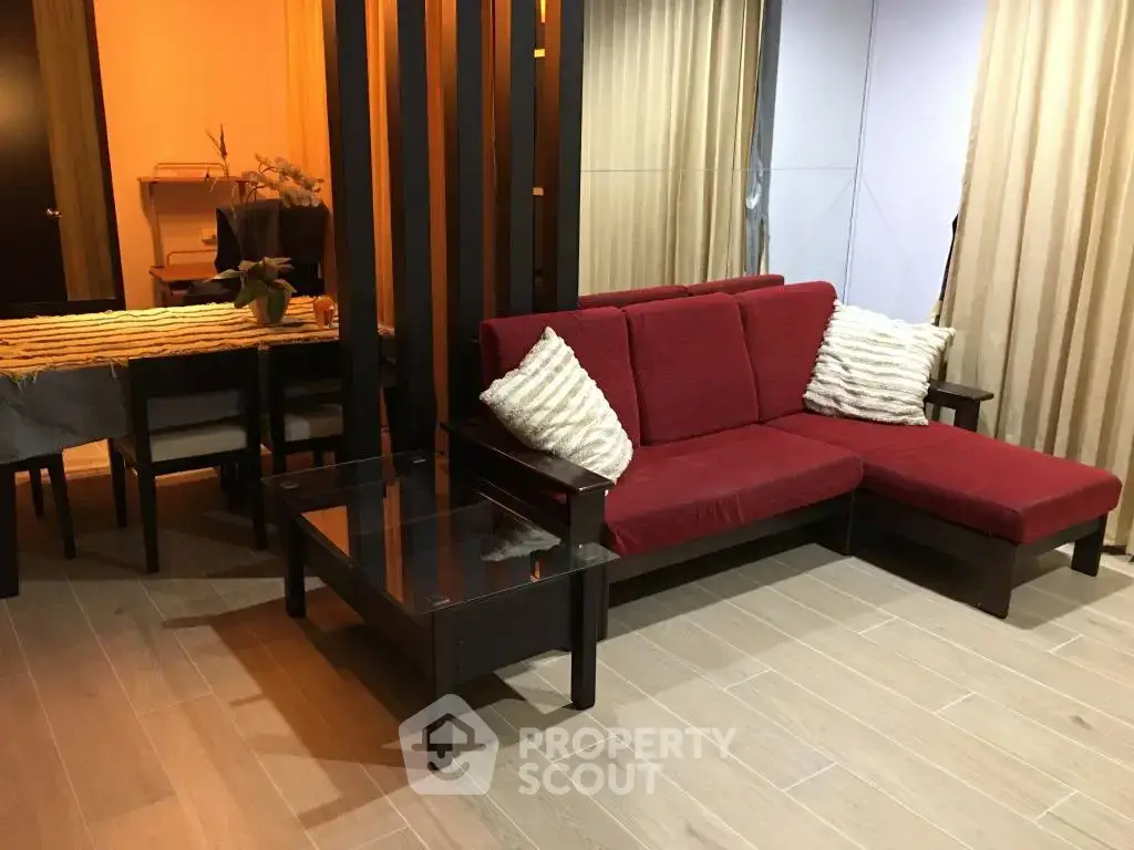 Modern living room with red sectional sofa and elegant dining area, perfect for stylish urban living.