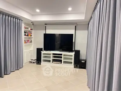 Modern living room with large TV and stylish curtains