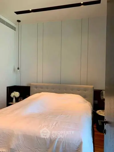 Cozy bedroom with modern design and elegant lighting, featuring a plush bed and stylish decor.