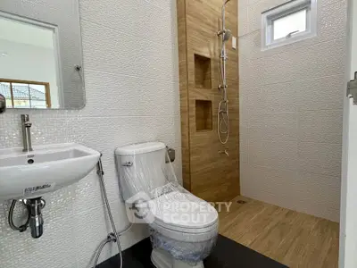 Modern bathroom with sleek fixtures and walk-in shower in a contemporary home.
