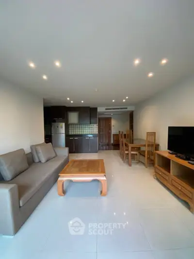 Spacious modern living room with open kitchen and elegant wooden furniture.