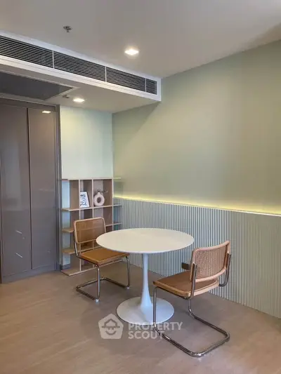 Modern dining area with stylish chairs and round table in a contemporary apartment.