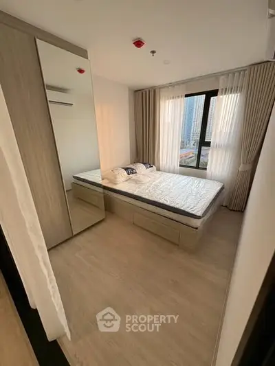 Modern bedroom with large window and stylish decor in urban apartment