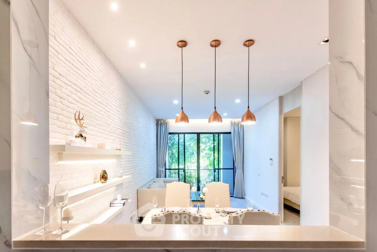 Luxurious open-plan living room with elegant decor and large windows offering a serene garden view.