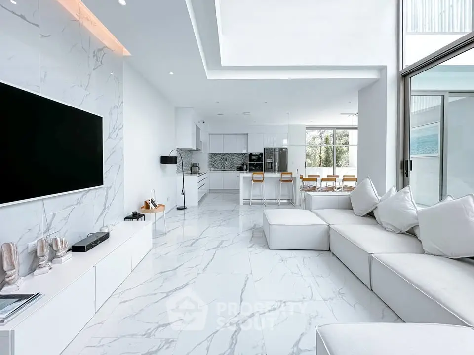 Luxurious open-plan living room with modern marble flooring and sleek white furniture, perfect for entertaining.