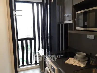 Modern kitchen with sleek appliances and balcony view