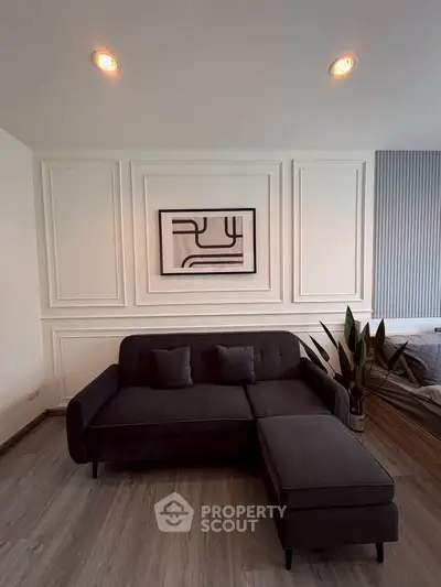Modern living room with stylish dark sofa and elegant wall paneling