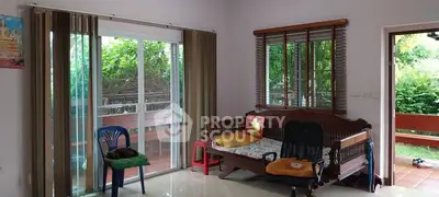 Cozy living room with sliding glass doors leading to a lush garden view.