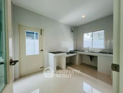 Spacious modern kitchen with sleek countertops and ample natural light.