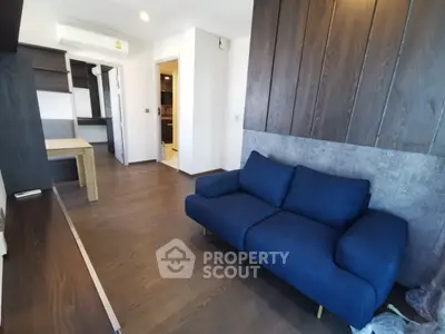 Modern living room with stylish blue sofa and wooden flooring