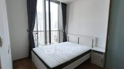 Modern bedroom with large windows and city view in a high-rise apartment.