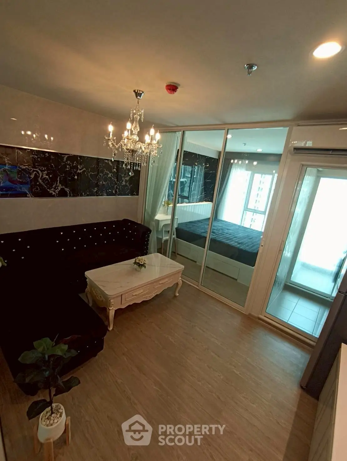 Luxurious living room with elegant chandelier and mirrored wardrobe in modern apartment